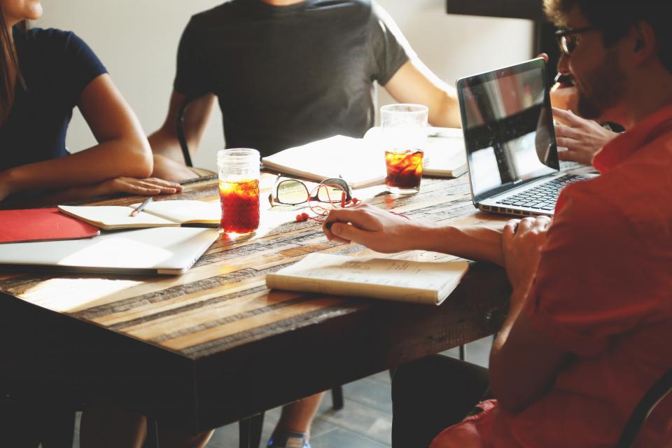 Business team collaborating around a table with laptops in a Toronto office